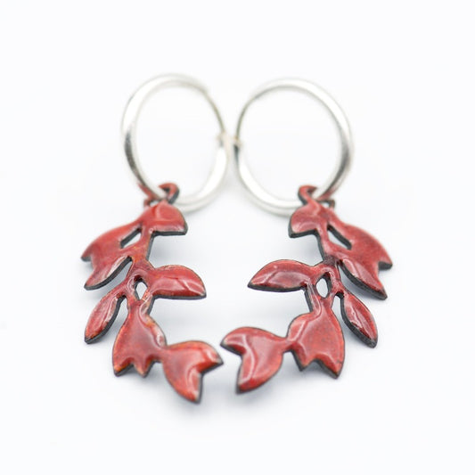 Sterling silver hoop earrings featuring a stylized dangling leafy branch crafted with glass enamel cloisonné on copper. Red colour enamel