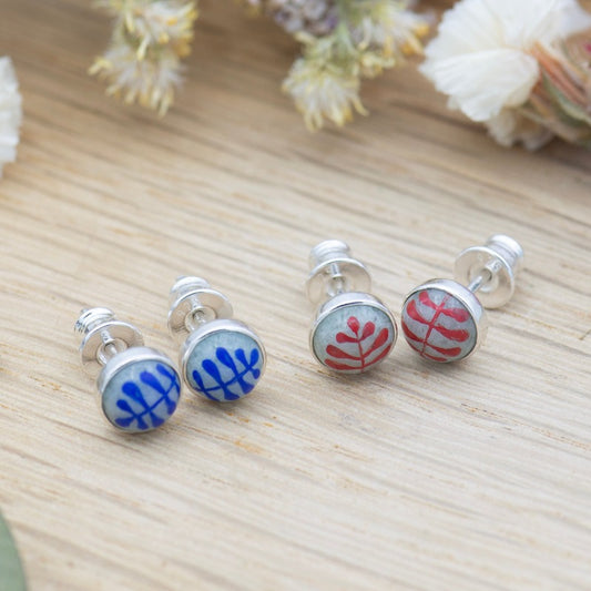 Medium round cabochon studs in sterling silver and glass, featuring a delicate painting of a stylized round leaf. 