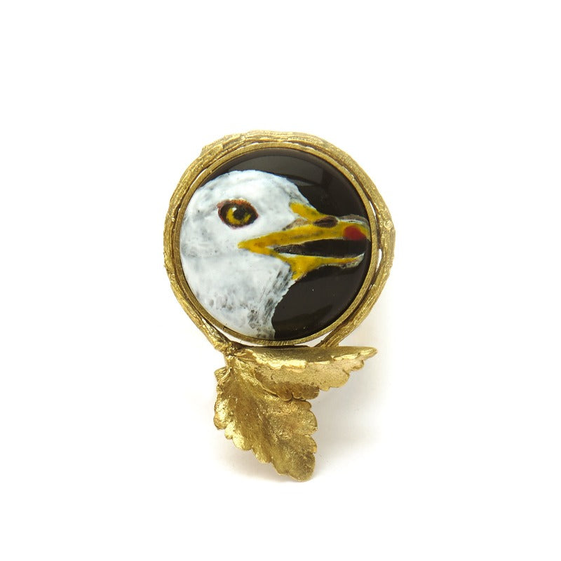 Hand-painted seagull head on upcycled glass cabochon, set in an 18k gold-plated, handmade botanical round setting statement ring. Delicate miniature painting setted in a round setting featuring a realistic small tree branch with two small leaves. Black background. Realistic adjustable tree branch ring.