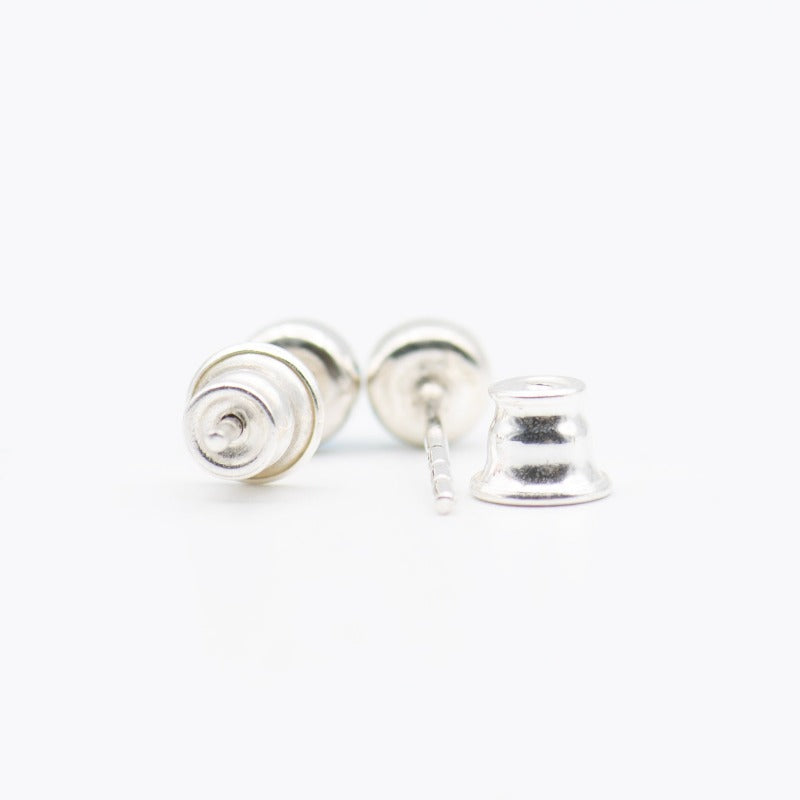 Small round cabochon studs in sterling silver and glass, featuring a tiny upcycled round glass. 