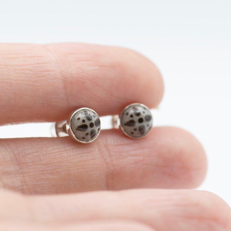 Medium round cabochon studs in sterling silver and glass, featuring a delicate painting of a stylized star. Grey background and brown star.