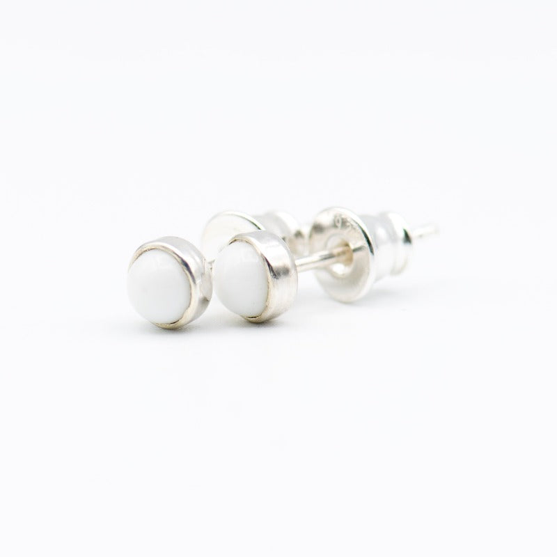 Small round cabochon studs in sterling silver and glass, featuring a tiny upcycled round glass. White glass