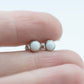 Small round cabochon studs in sterling silver and glass, featuring a tiny upcycled round glass. White glass