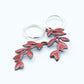 Sterling silver hoop earrings featuring a stylized dangling leafy branch crafted with glass enamel cloisonné on copper. Red colour enamel