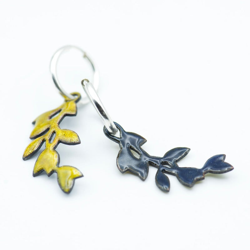 Sterling silver hoop earrings featuring a stylized dangling leafy branch crafted with glass enamel cloisonné on copper. Yellow colour enamel. Back in a dark blue counter-enamel.