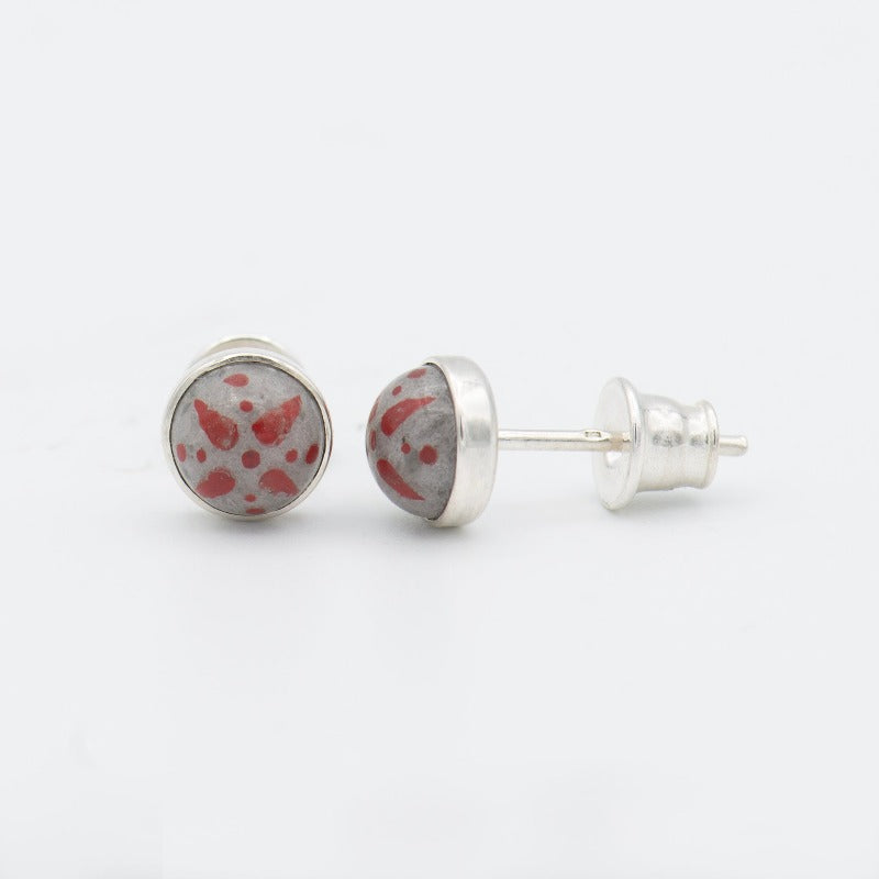 Medium round cabochon studs in sterling silver and glass, featuring a delicate painting of a stylized star. Grey background and red star.