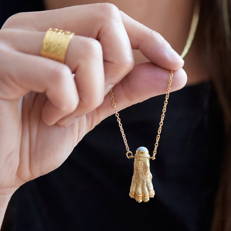 Realistic lion paw sculpture crafted in 18k gold-plated brass, featuring a small upcycled glass set on top. Evokes an ancient Roman jewelry vibe, complemented by a delicate stainless steel chain