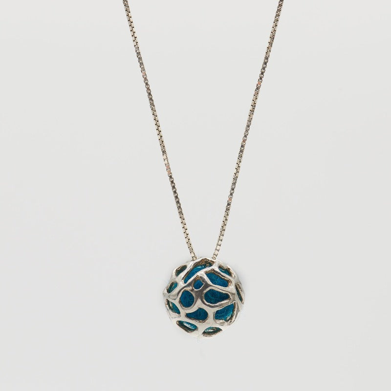 Sterling silver pendant featuring a simple hollow organic shape with colored wool inside, visible through the outer layer. The sphere measures approximately 1.5 cm, paired with a 60 cm sterling silver chain. Blue wool