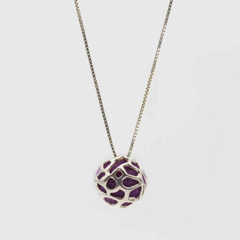 Sterling silver pendant featuring a simple hollow organic shape with colored wool inside, visible through the outer layer. The sphere measures approximately 1.5 cm, paired with a 60 cm sterling silver chain. Purple wool