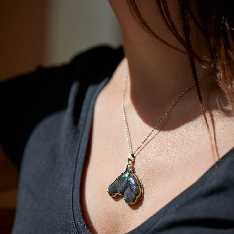 Hand-sculpted glass black horse head framed in brass and sterling silver setting, complemented by a delicate sterling silver chain. 45 cm chain with a add-on of 5 cm for size adjustment.